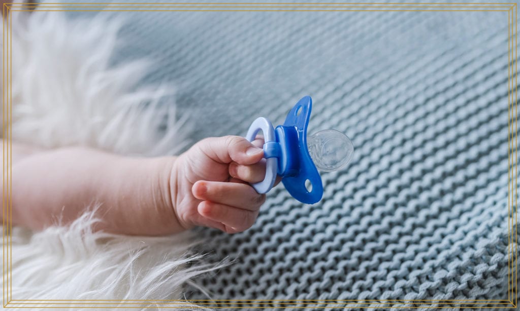 baby holding pacifier